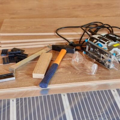 Herramientas sobre un suelo de madera junto a película para paneles.