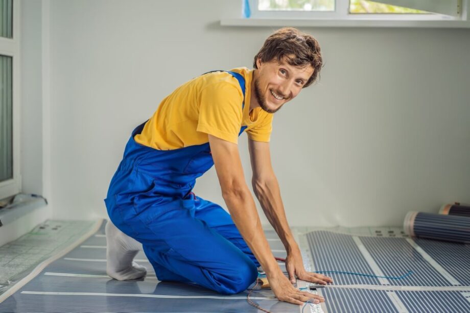 Un trabajador instala un folio radiante en el suelo de una habitación.