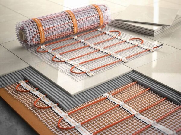 Un conjunto de alfombrillas calefactoras listas para ser instaladas bajo el suelo de azulejos.