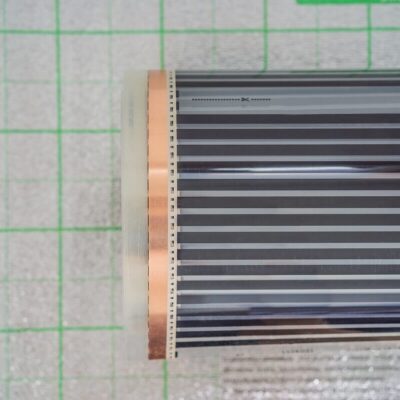 Una película calefactora enrollada sobre una superficie cuadriculada.