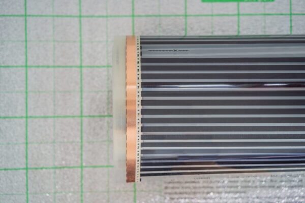 Una película calefactora enrollada sobre una superficie cuadriculada.