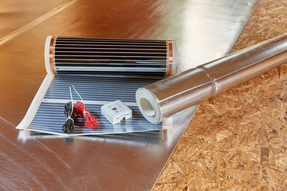 Un folio radiante junto a un rollo de aislamiento térmico y accesorios eléctricos.