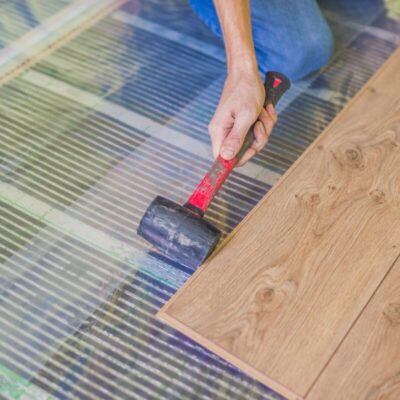 Una persona instala un suelo utilizando película para paneles.