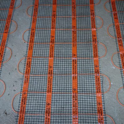 Las alfombrillas calefactoras están instaladas sobre el suelo de cemento.